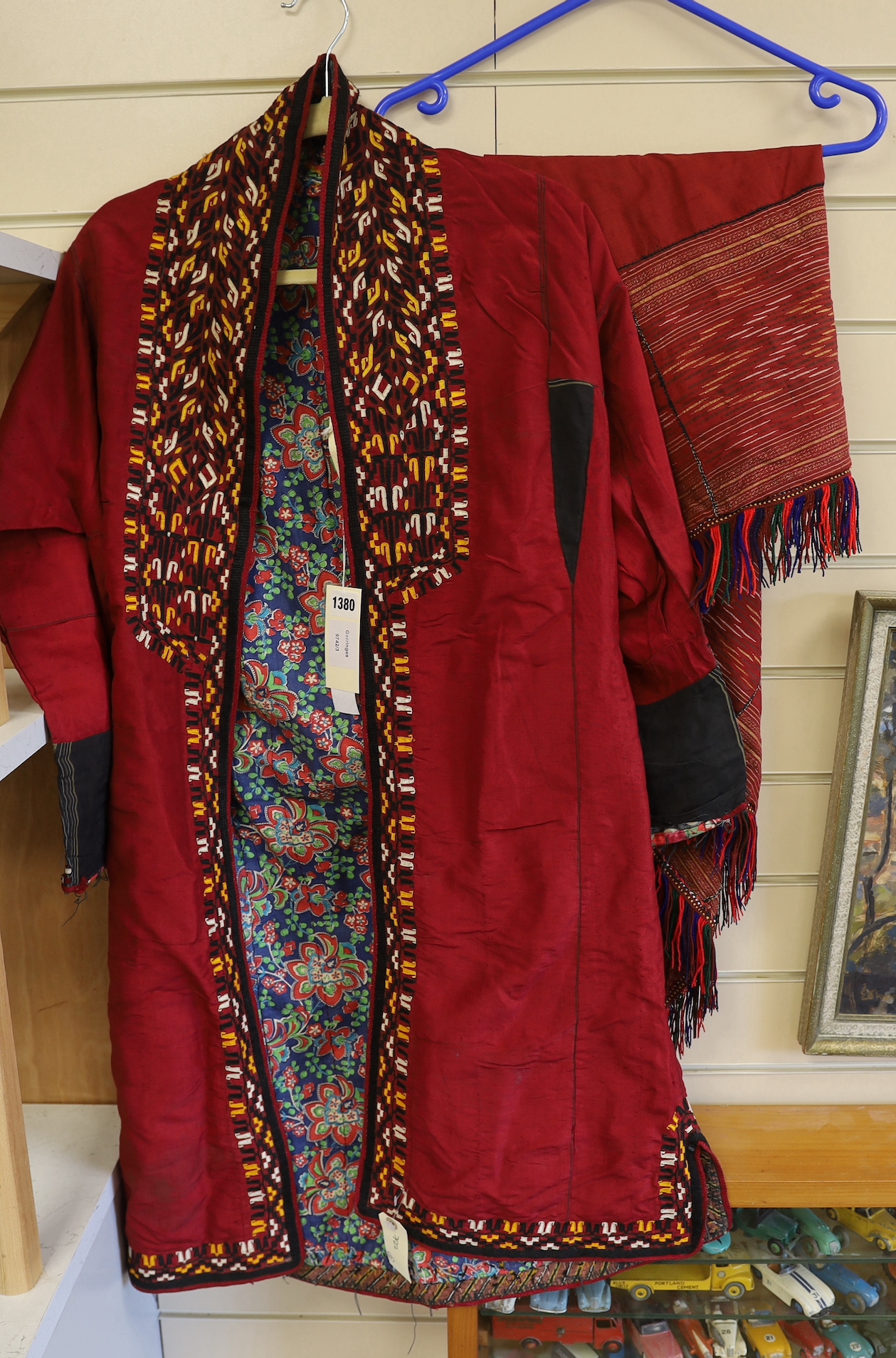 A Tekke Turkoman woman's red ground robe (khalat), the collar embroidered with red, gold and white devices, together with a red triangular shawl, longest side (2)